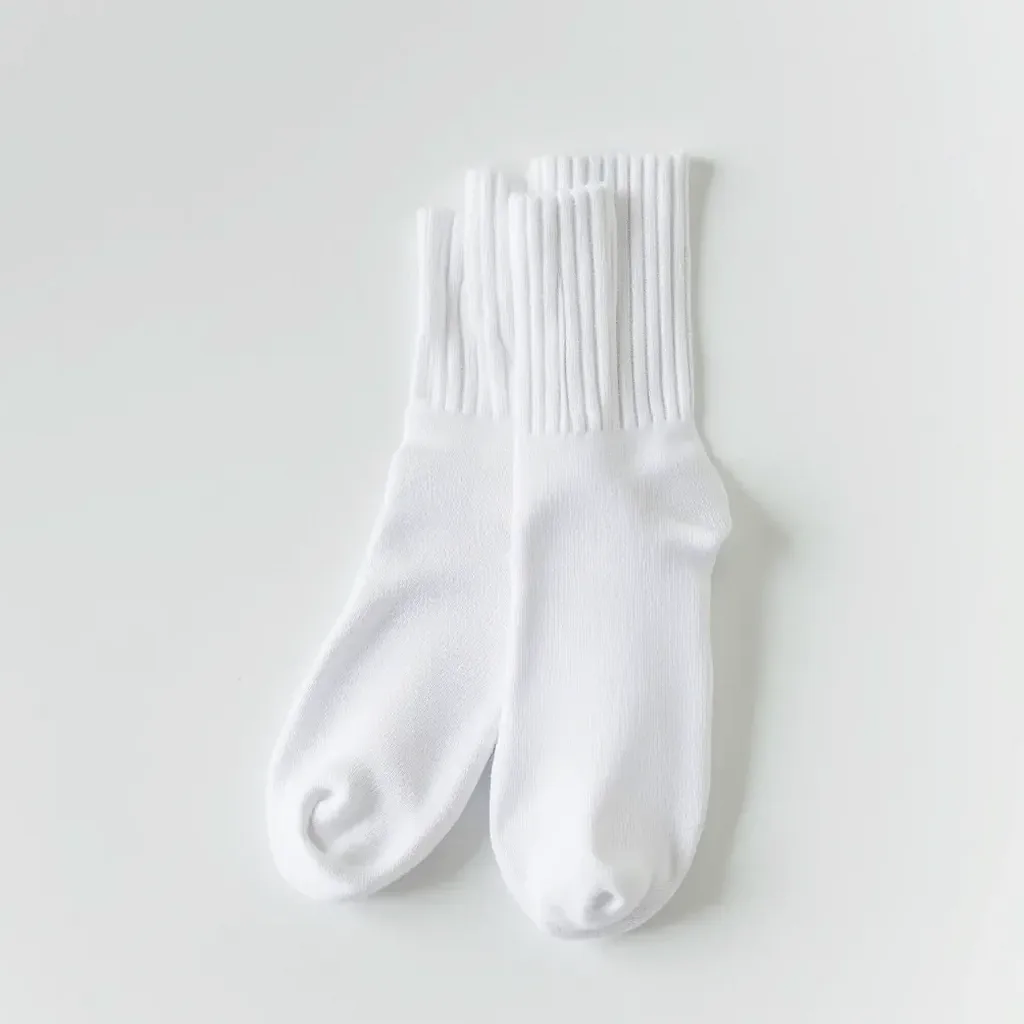 Clean white running socks laid out on a fresh white surface, illustrating proper care and upkeep of athletic socks